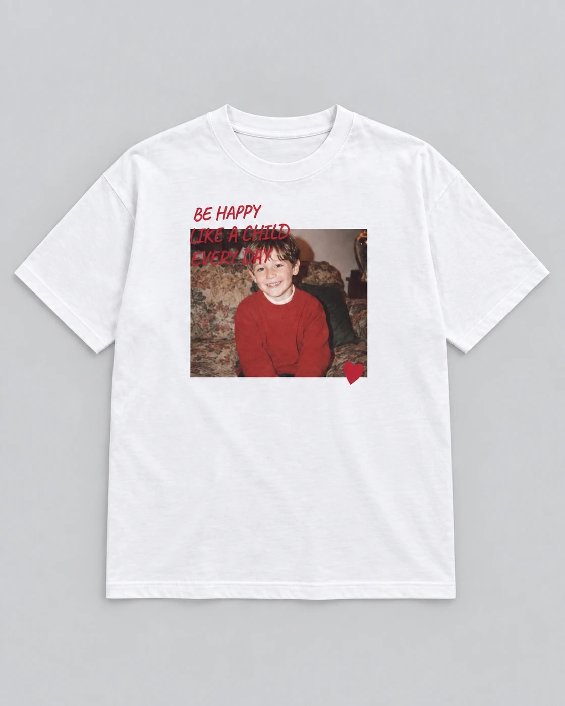 T-shirt blanc Comme un enfant, posé à plat sur fond gris