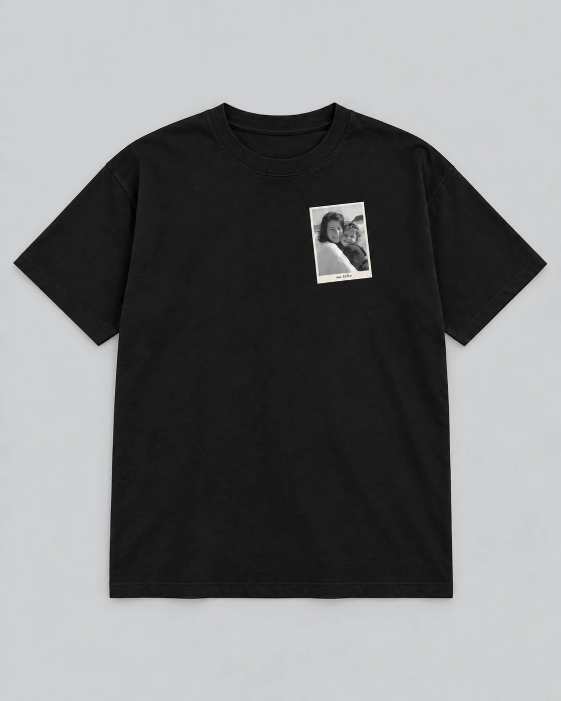 T-shirt noir Près du cœur, posé à plat sur fond gris