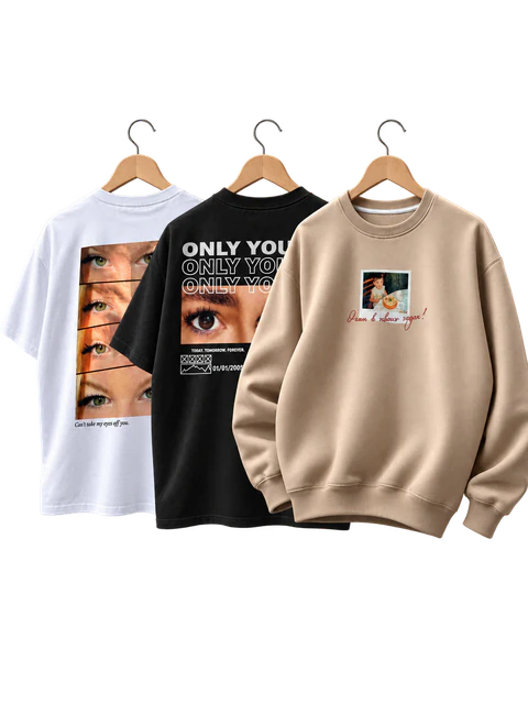 Trois vêtements sur cintres : un t-shirt blanc à bande de regards, un t-shirt noir « only you », un sweat beige à polaroid